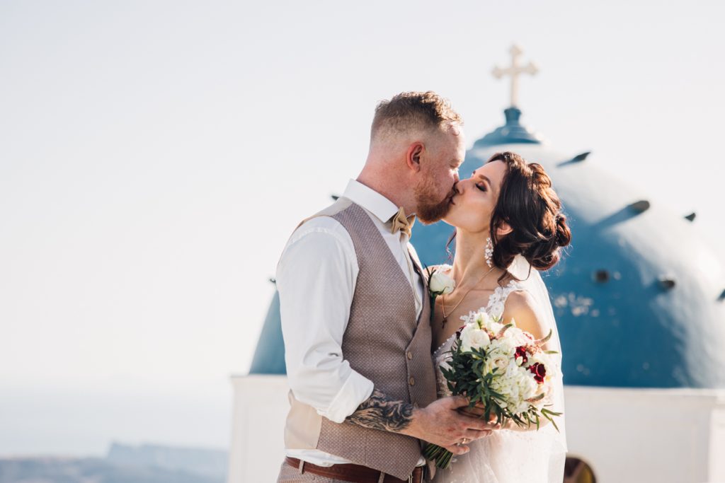 Professional wedding photographer in Santorini: couple shooting among blue domes