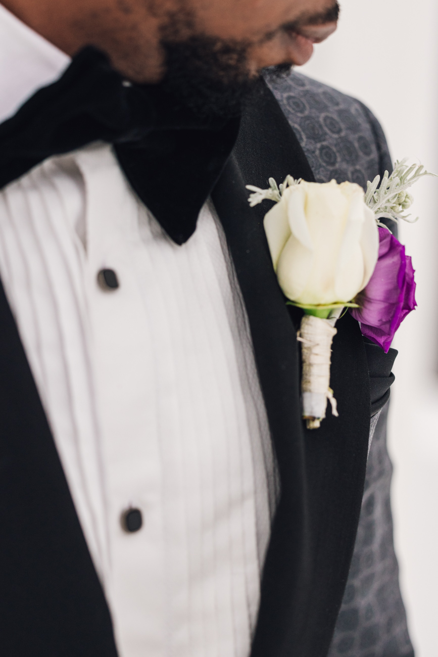 Close-up of groom's boutonniere with a delicate white rose