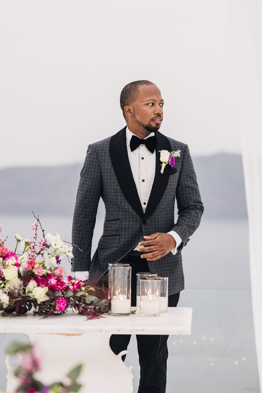 Groom standing proudly in front of a picturesque landscape