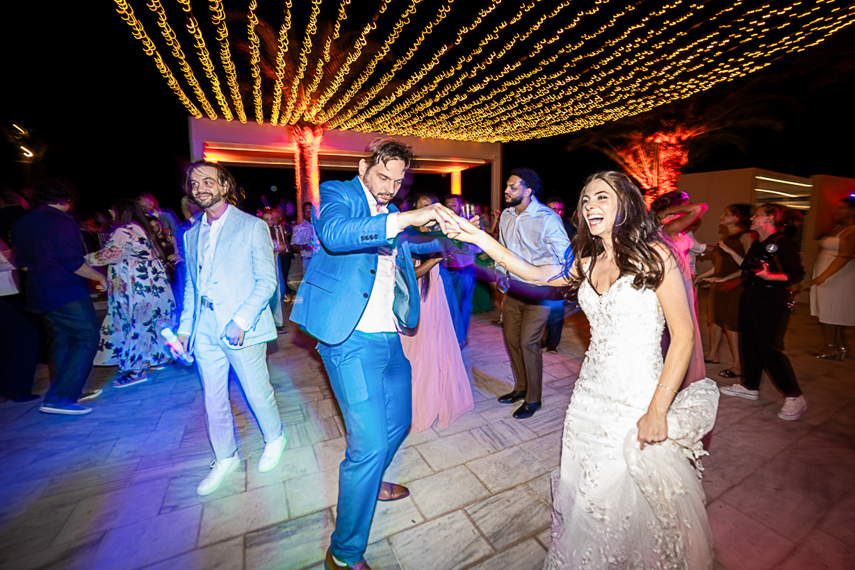Happy bride dancing with her friends during the celebration at the Amphitheatre Lindos.